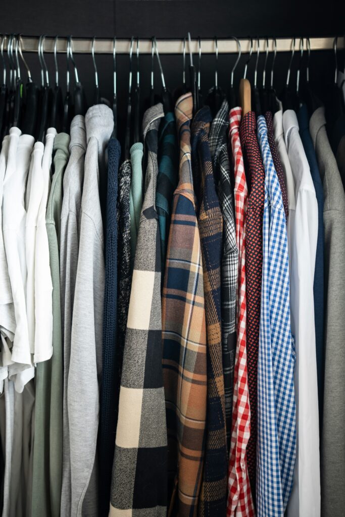 Row of hanging shirts in assorted colors and patterns on a closet rod